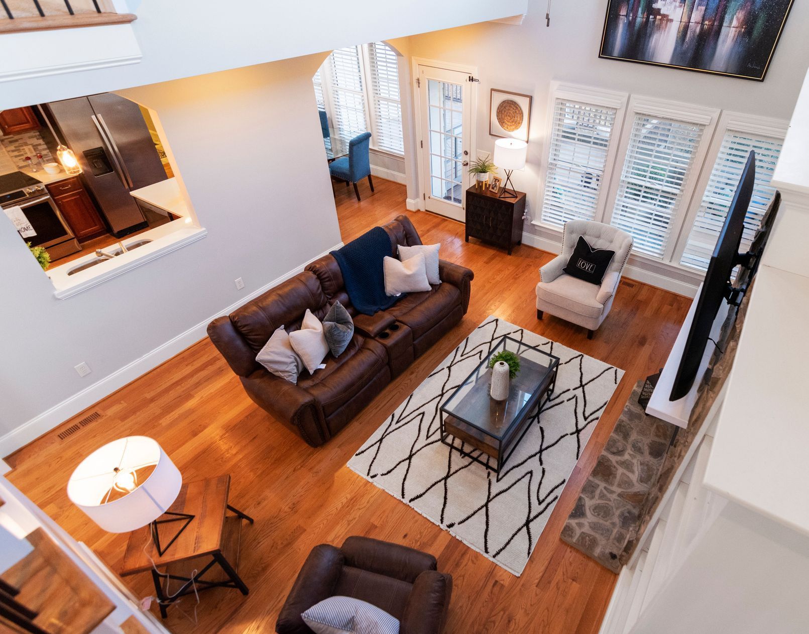 Elegant living room with leather sofas, soft lighting, and modern decor viewed from above.